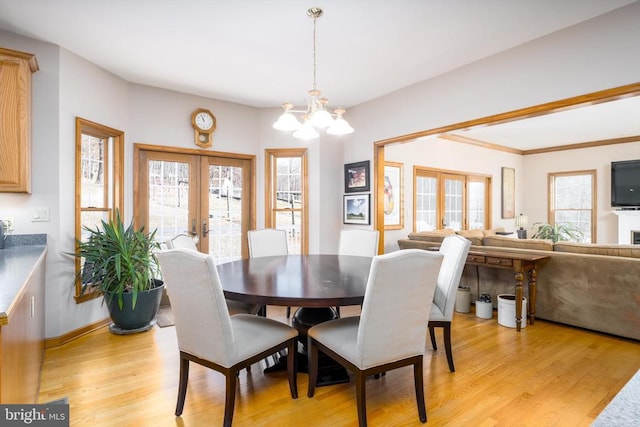 dining space with french doors, plenty of natural light, and light wood-style floors