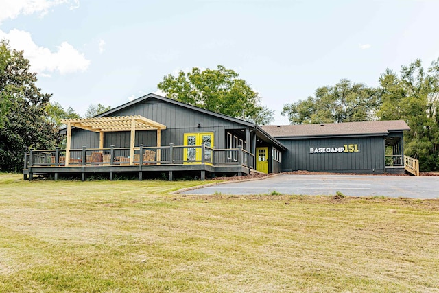 view of front of house with a front yard, a deck, and a pergola