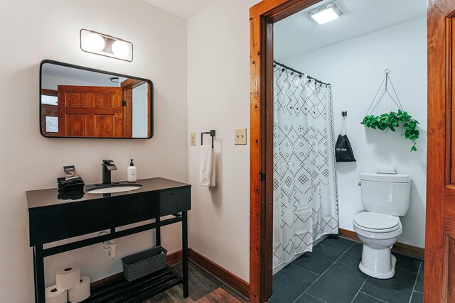 bathroom featuring sink, curtained shower, tile patterned floors, and toilet