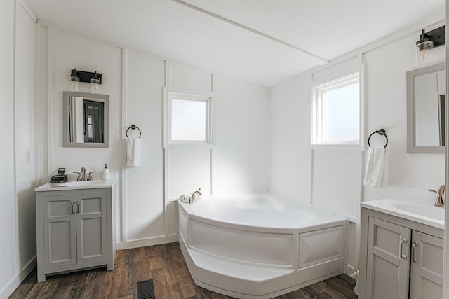 bathroom with vanity, hardwood / wood-style floors, and a bathing tub