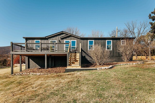 rear view of house with a deck and a lawn