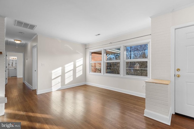 unfurnished living room with visible vents, baseboards, and wood finished floors