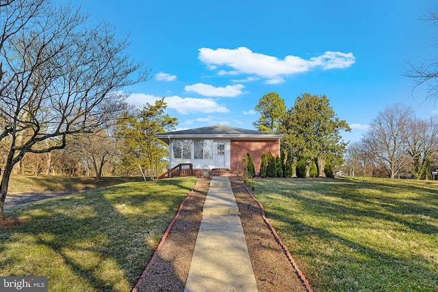 view of front facade with a front yard and brick siding