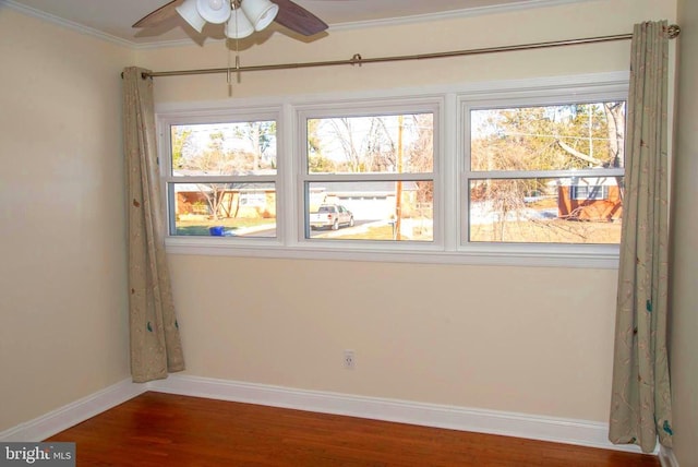 spare room with hardwood / wood-style flooring, crown molding, and ceiling fan