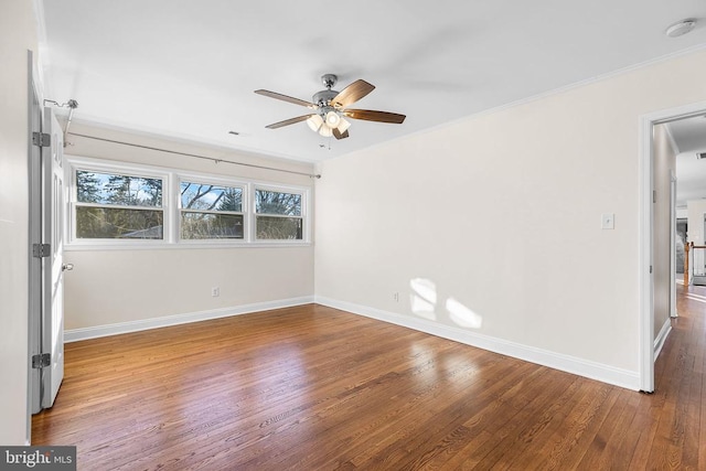 empty room featuring ceiling fan, baseboards, wood finished floors, and ornamental molding