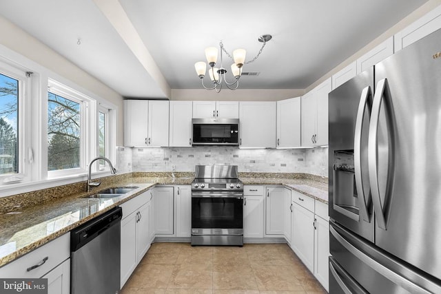 kitchen with decorative backsplash, visible vents, appliances with stainless steel finishes, and a sink