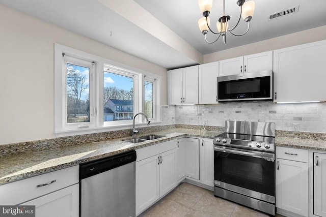 kitchen with visible vents, backsplash, appliances with stainless steel finishes, white cabinetry, and a sink