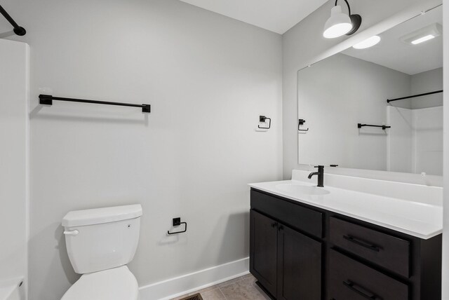 bathroom with tile patterned flooring, vanity, a shower, and toilet