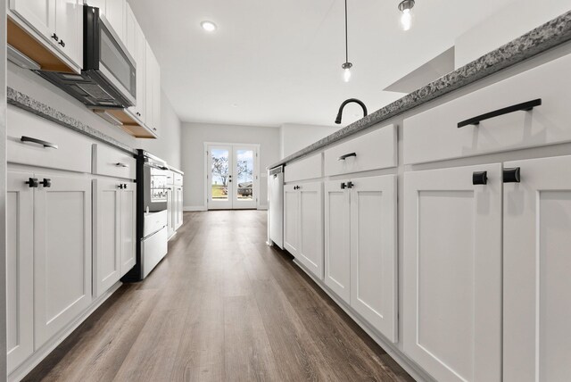 kitchen with dishwasher, dark hardwood / wood-style floors, pendant lighting, and white cabinets