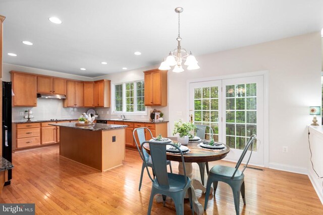 kitchen featuring pendant lighting, sink, a center island, and light hardwood / wood-style floors