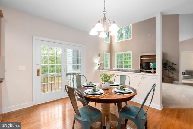 dining space featuring a healthy amount of sunlight, a chandelier, and light wood-type flooring