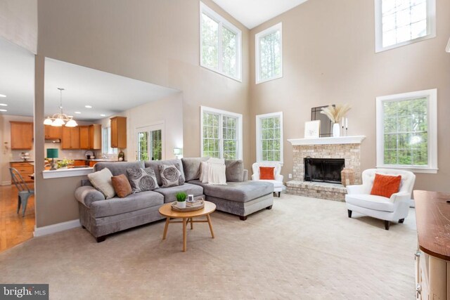 living room with an inviting chandelier, a fireplace, and plenty of natural light