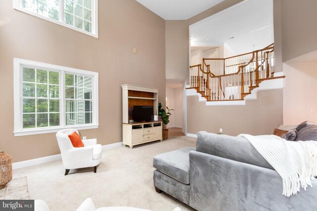 carpeted living room with a high ceiling