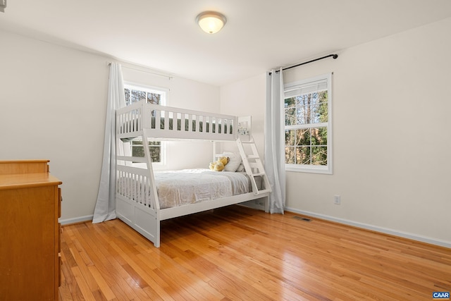 unfurnished bedroom featuring baseboards, visible vents, and light wood-style floors