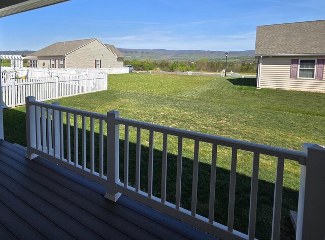 wooden terrace with a lawn and a mountain view