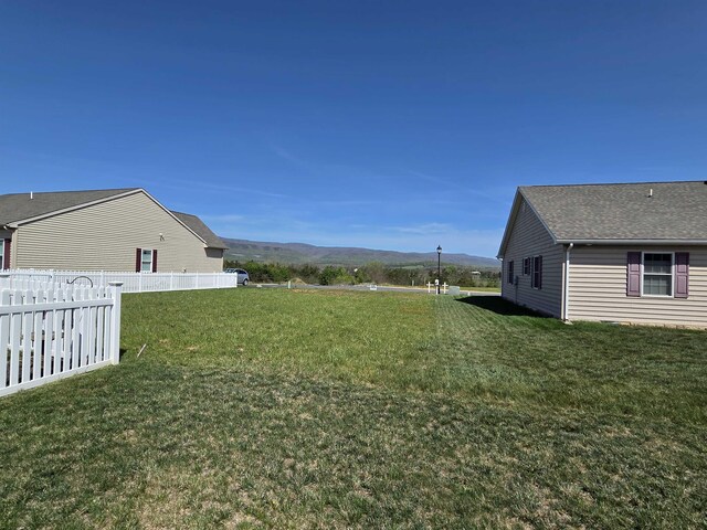 view of yard with a mountain view and fence