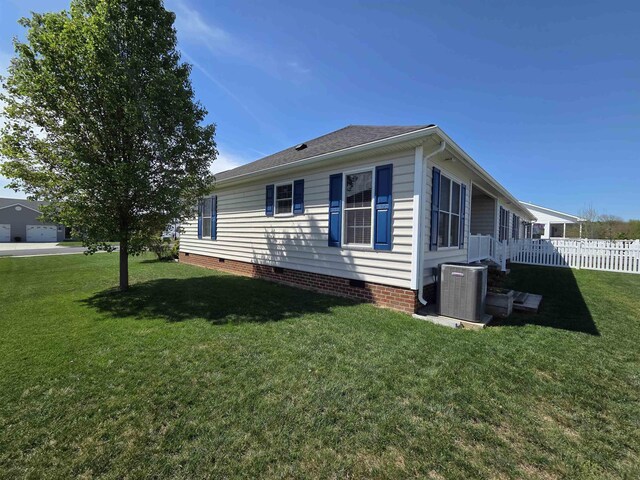 view of home's exterior with a lawn, crawl space, central AC unit, and fence