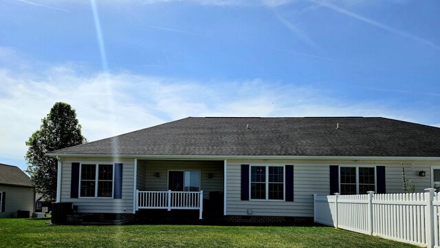 back of house with fence, a yard, a shingled roof, and crawl space