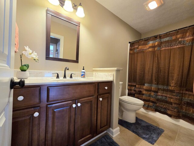 full bath with a shower with curtain, tile patterned floors, vanity, and toilet