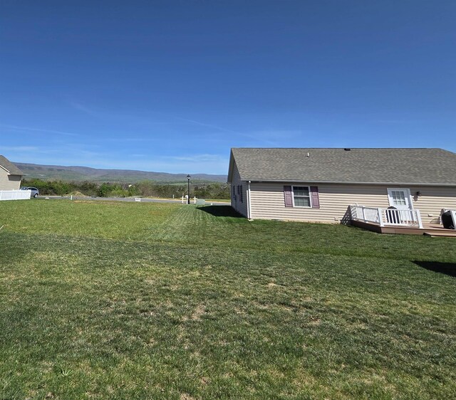 view of yard with a deck with mountain view