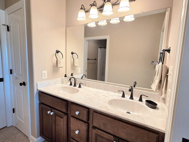bathroom with tile patterned floors, a sink, and double vanity