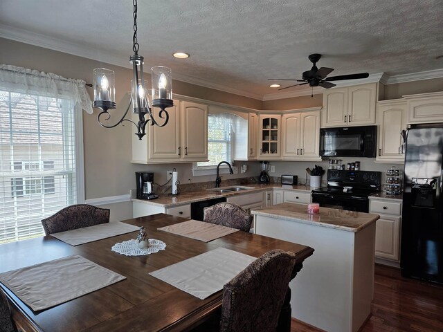 kitchen featuring a sink, ceiling fan with notable chandelier, pendant lighting, crown molding, and black appliances