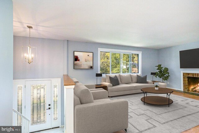 living room with an inviting chandelier and a brick fireplace