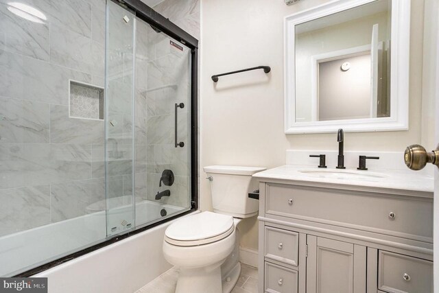 full bathroom featuring bath / shower combo with glass door, vanity, and toilet