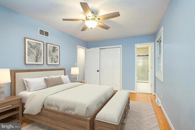 bedroom featuring ceiling fan, a closet, connected bathroom, and light hardwood / wood-style flooring