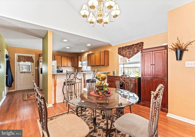 dining room featuring recessed lighting, light wood-style flooring, baseboards, and an inviting chandelier