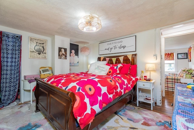 bedroom featuring wood finished floors and a textured ceiling
