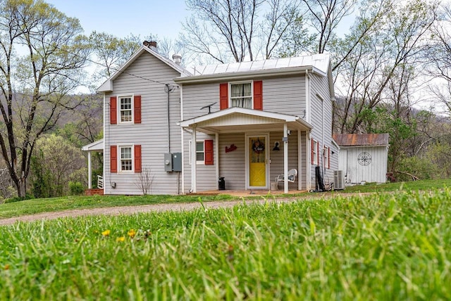 traditional-style home with a storage shed, covered porch, and an outdoor structure