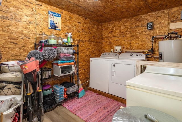 laundry area featuring washing machine and dryer, water heater, wood finished floors, and laundry area
