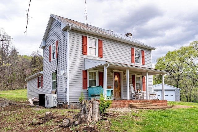 american foursquare style home featuring a detached garage, a chimney, covered porch, ac unit, and an outbuilding