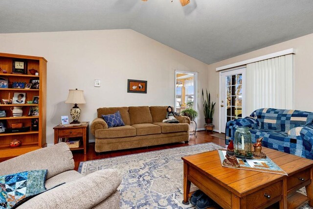 living room featuring ceiling fan, wood-type flooring, and vaulted ceiling