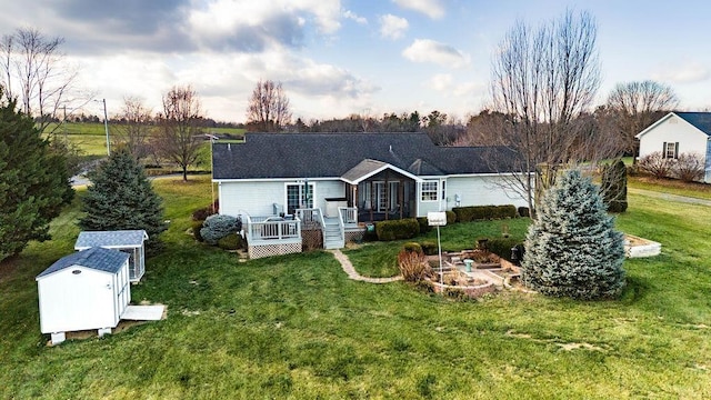 back of house with a storage shed, a yard, and a deck