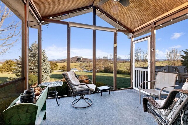 sunroom with lofted ceiling, a rural view, and wooden ceiling