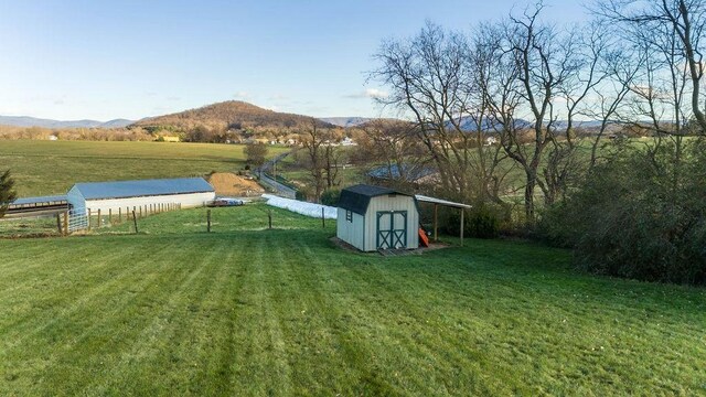 view of yard featuring a mountain view, a rural view, and a storage unit