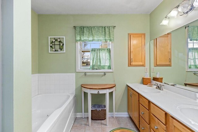 bathroom featuring vanity, tile patterned flooring, a tub, and a healthy amount of sunlight