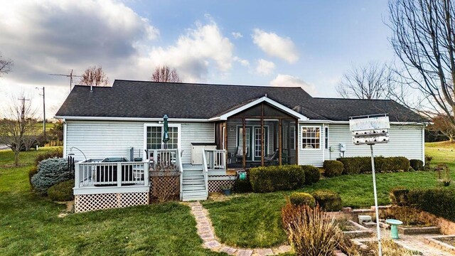 rear view of property with a lawn and a deck