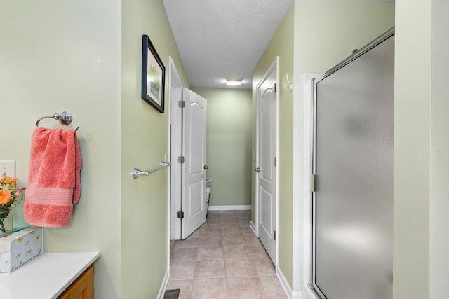 bathroom featuring tile patterned flooring, vanity, and walk in shower