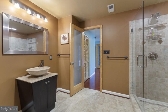 bathroom featuring vanity and a shower with door