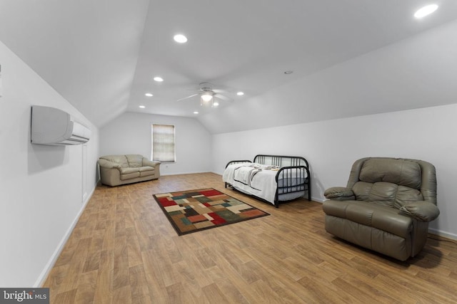 bedroom featuring ceiling fan, vaulted ceiling, a wall unit AC, and light hardwood / wood-style flooring