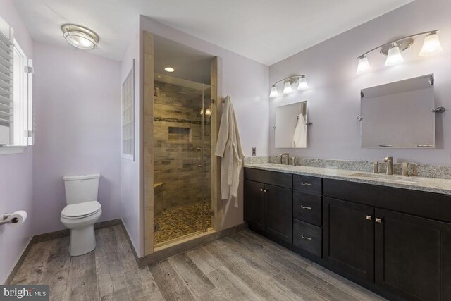 bathroom featuring hardwood / wood-style flooring, vanity, toilet, and walk in shower