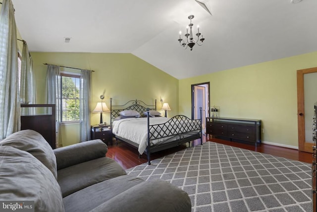 bedroom with an inviting chandelier, lofted ceiling, and hardwood / wood-style floors