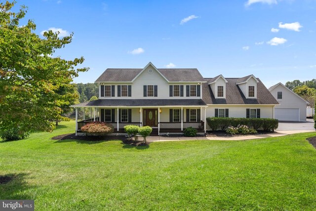 view of front of house with a garage, a front lawn, and a porch