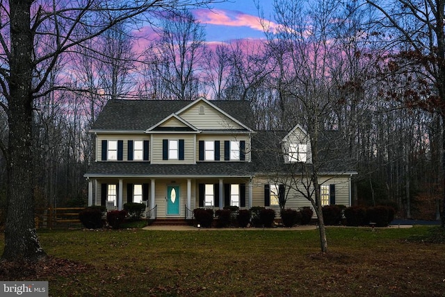 view of front of property featuring a porch and a lawn