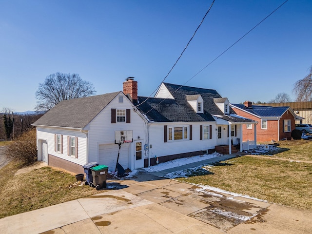 exterior space featuring driveway, a garage, a chimney, roof with shingles, and a yard