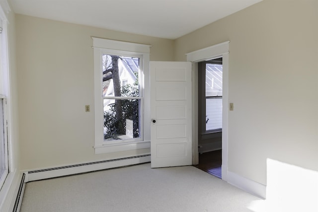 spare room featuring carpet flooring and a baseboard heating unit