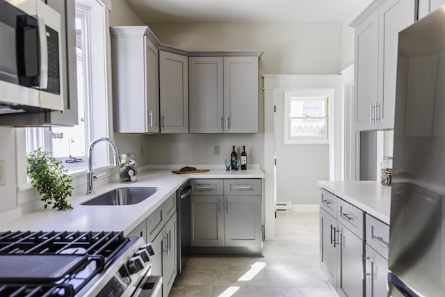 kitchen featuring refrigerator, a healthy amount of sunlight, gray cabinets, and sink